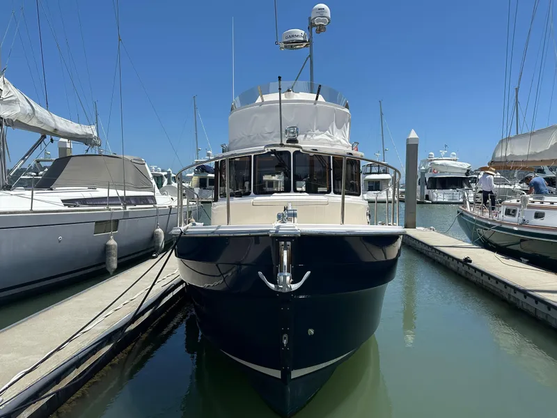 Slide: The Image of 2023 Ranger Tugs R-31 CB docked at marina under clear blue sky. - 2
