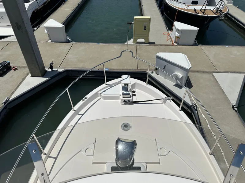 Slide: The Image of 2023 Ranger Tugs R-31 CB docked at a marina, viewed from the bow. - 26