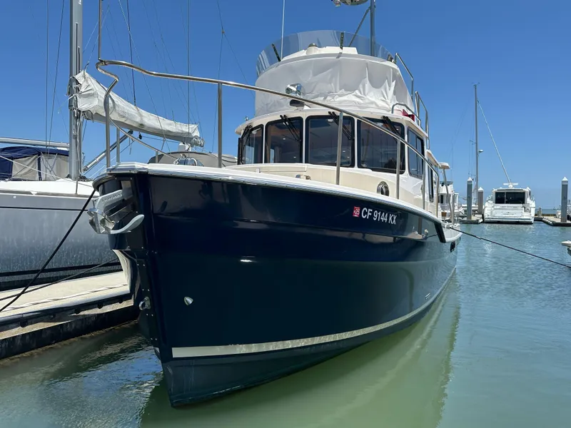 Slide: The Image of 2023 Ranger Tugs R-31 CB boat docked in marina under clear blue sky. - 3