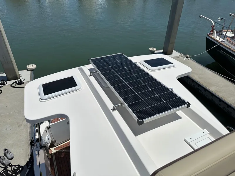 Slide: The Image of 2023 Ranger Tugs R-31 CB with solar panel on deck, docked by the water. - 31