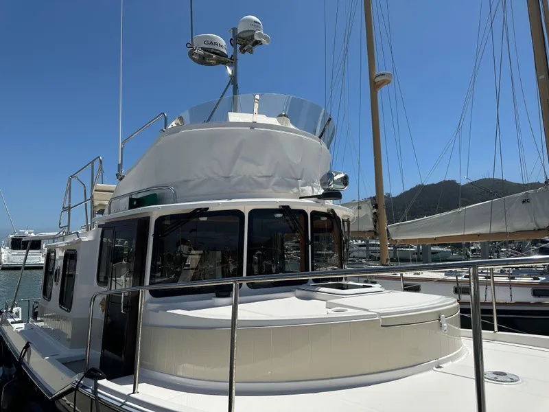 Slide: The Image of 2023 Ranger Tugs R-31 CB boat docked in a marina under clear blue sky. - 33