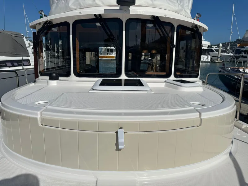 Slide: The Image of 2023 Ranger Tugs R-31 CB boat docked at a marina, showcasing its cabin and deck. - 35
