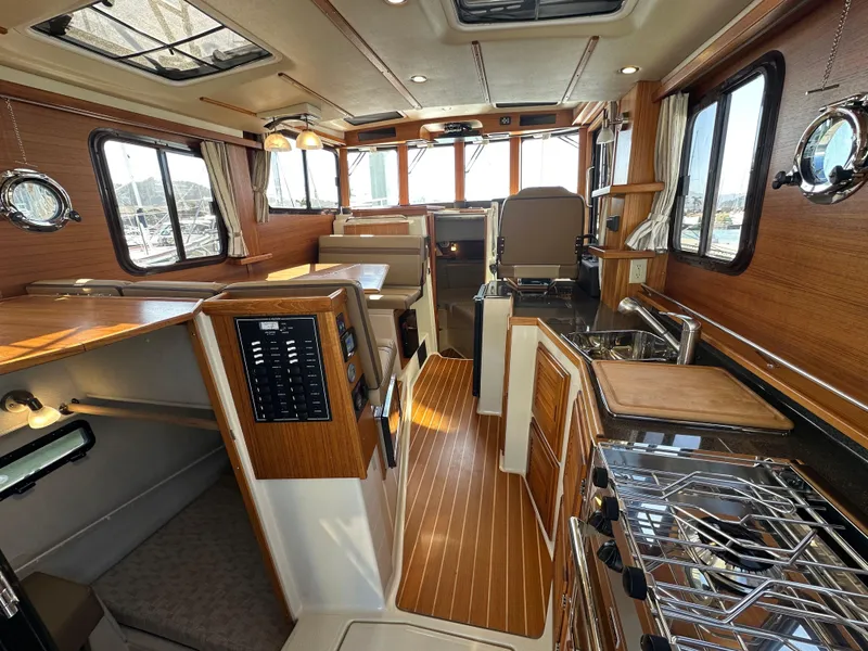 Slide: The Image of 2023 Ranger Tugs R-31 CB interior with wood accents and modern amenities. - 37