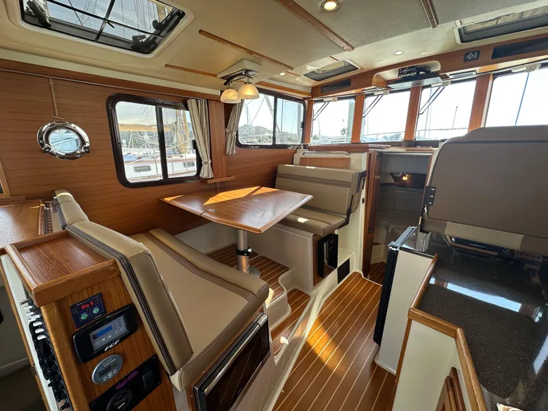 Slide: The Image of Interior of 2023 Ranger Tugs R-31 CB, featuring elegant wood finishes and comfortable seating. - 39