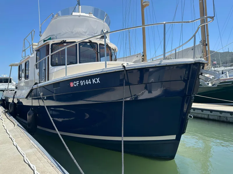 Slide: The Image of 2023 Ranger Tugs R-31 CB boat docked at marina, blue hull, sunny day. - 4