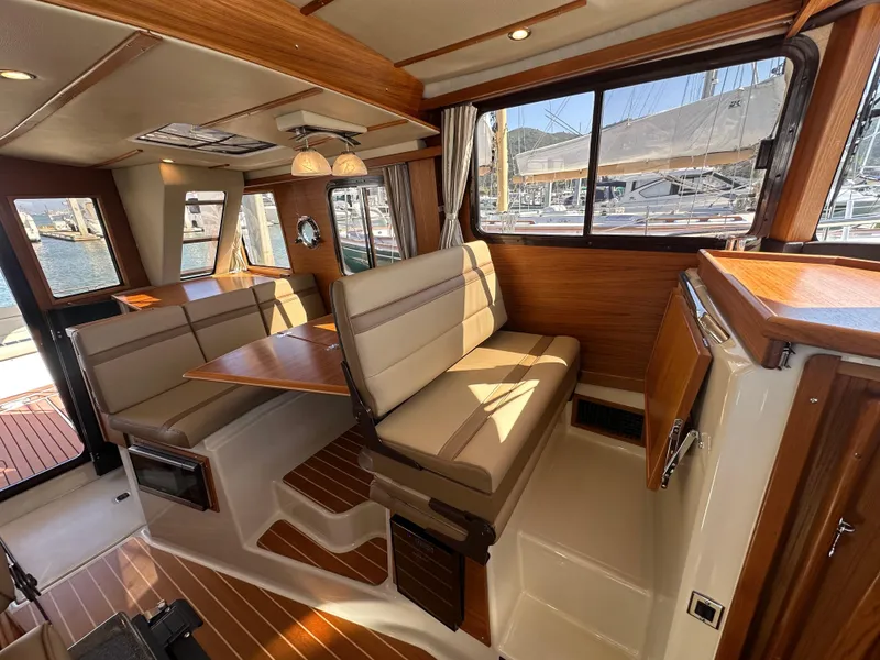 Slide: The Image of 2023 Ranger Tugs R-31 CB interior with wood accents and seating area. - 41