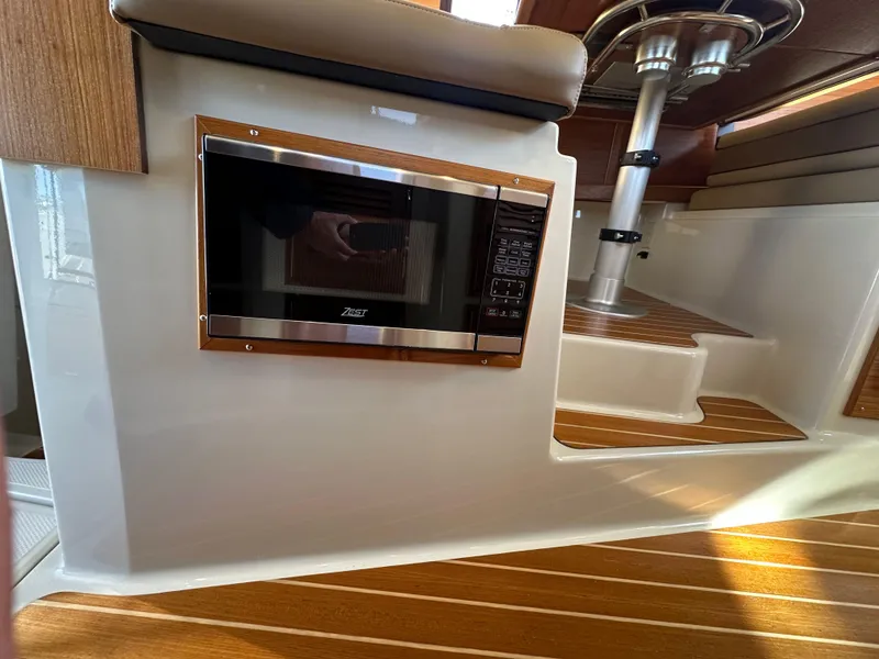Slide: The Image of 2023 Ranger Tugs R-31 CB interior with microwave and wooden flooring. - 45