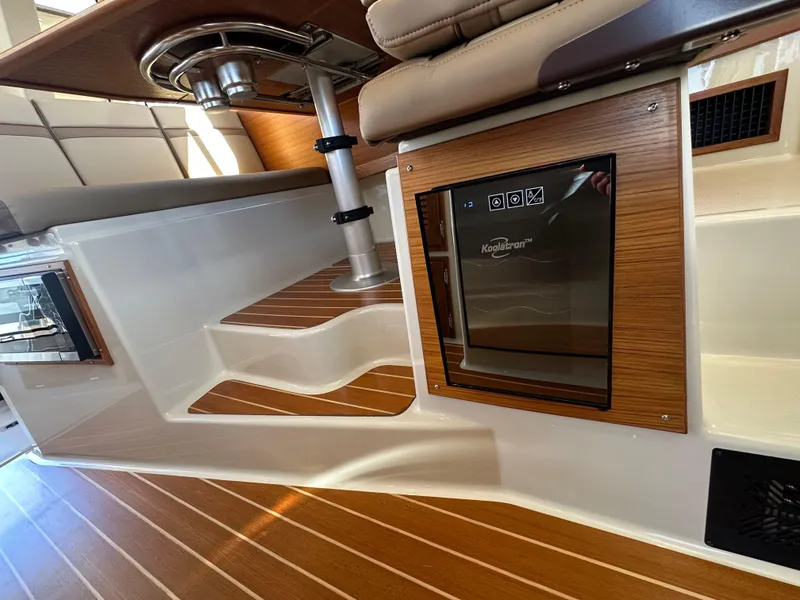 Slide: The Image of 2023 Ranger Tugs R-31 CB interior with wood accents and built-in refrigerator. - 46