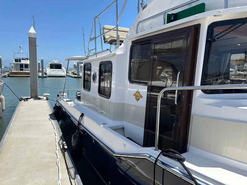 Slide: The Image of 2023 Ranger Tugs R-31 CB docked at marina under clear blue sky. - 5