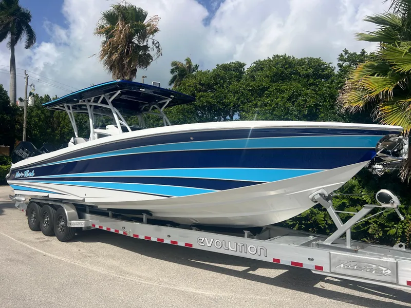 The Image of 2026 Nor-Tech 340 Sport boat cruising on a sunny day with triple engines. - 0