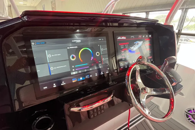 Slide: The Image of 2026 Nor-Tech 340 Sport boat in showroom, blue and white design, on trailer. - 13