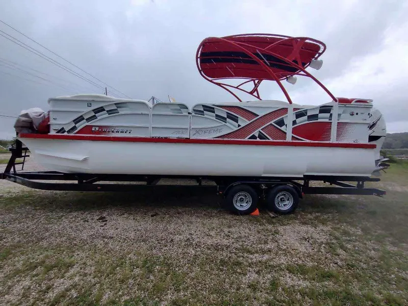 The Image of 2017 PlayCraft 2600 X-treme pontoon boat with red and white design on a trailer. - 0