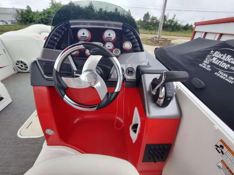 Slide: The Image of 2017 PlayCraft 2600 X-treme boat dashboard with steering wheel and control panel. - 2