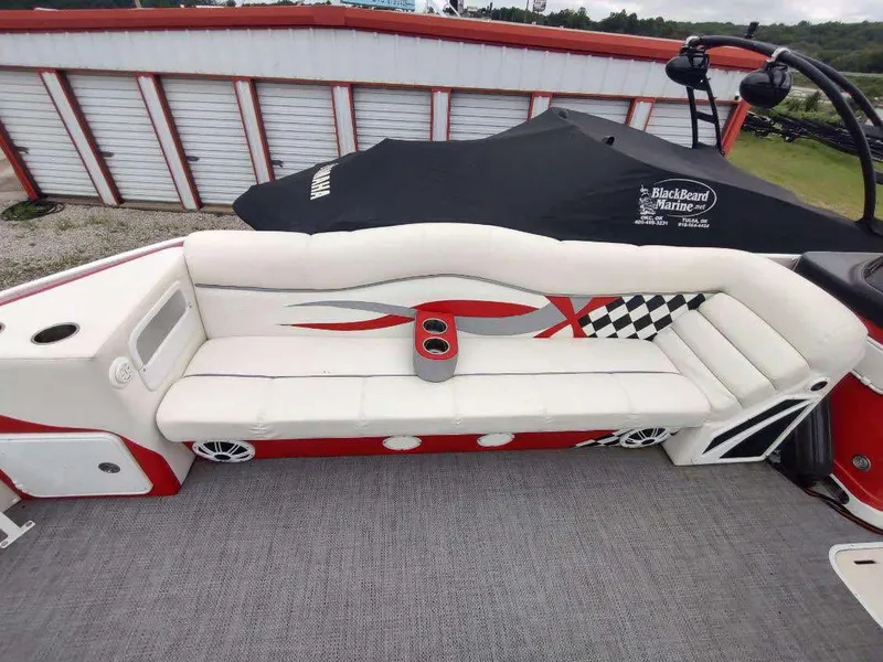 Slide: The Image of 2017 PlayCraft 2600 X-treme boat interior with white and red seating, cup holders, and checkered design. - 20