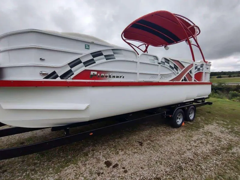 Slide: The Image of 2017 PlayCraft 2600 X-treme boat with red and black accents on a trailer. - 7