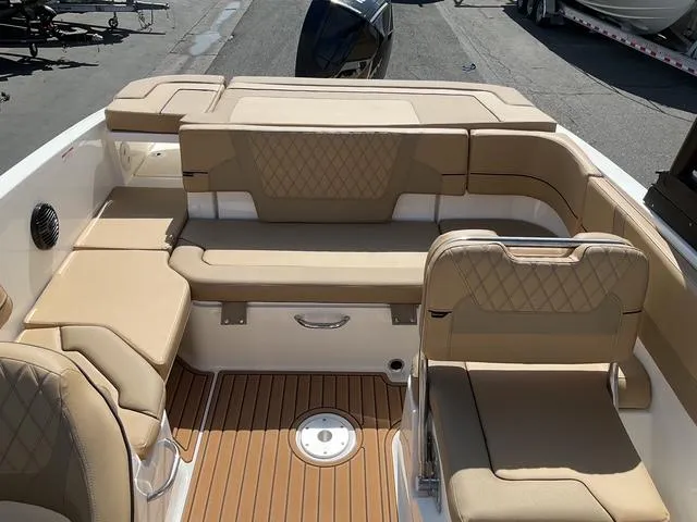 Slide: The Image of 2025 Bayliner VR6 Bowrider OB interior with tan seating and wood-style flooring. - 10