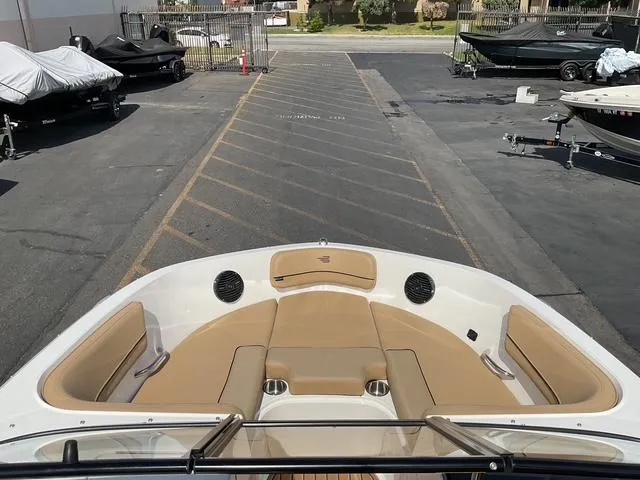 Slide: The Image of 2025 Bayliner VR6 Bowrider OB boat interior with tan seating in a marina setting. - 14