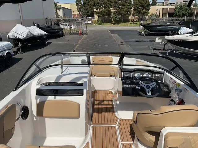 Slide: The Image of 2025 Bayliner VR6 Bowrider OB with tan interior, parked in a marina. - 16