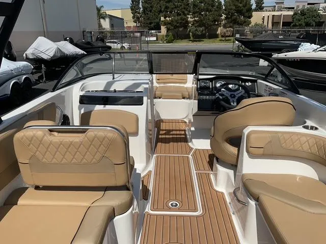 Slide: The Image of 2025 Bayliner VR6 Bowrider OB interior with tan seating and wood-style flooring. - 17