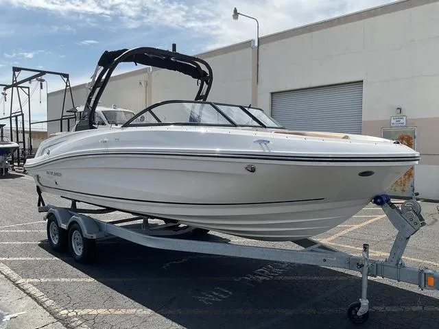 Slide: The Image of 2025 Bayliner VR6 Bowrider OB on trailer, parked outdoors near a building. - 3