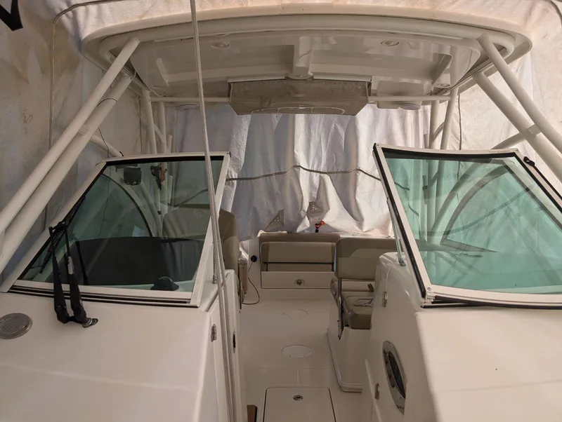 Slide: The Image of 2018 Sailfish 245DC boat interior with dual consoles and seating under a canopy. - 10