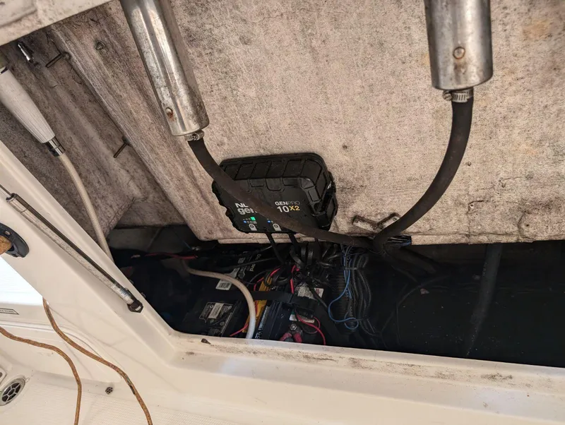 Slide: The Image of 2018 Sailfish 245DC boat battery compartment with wiring and charger. - 12
