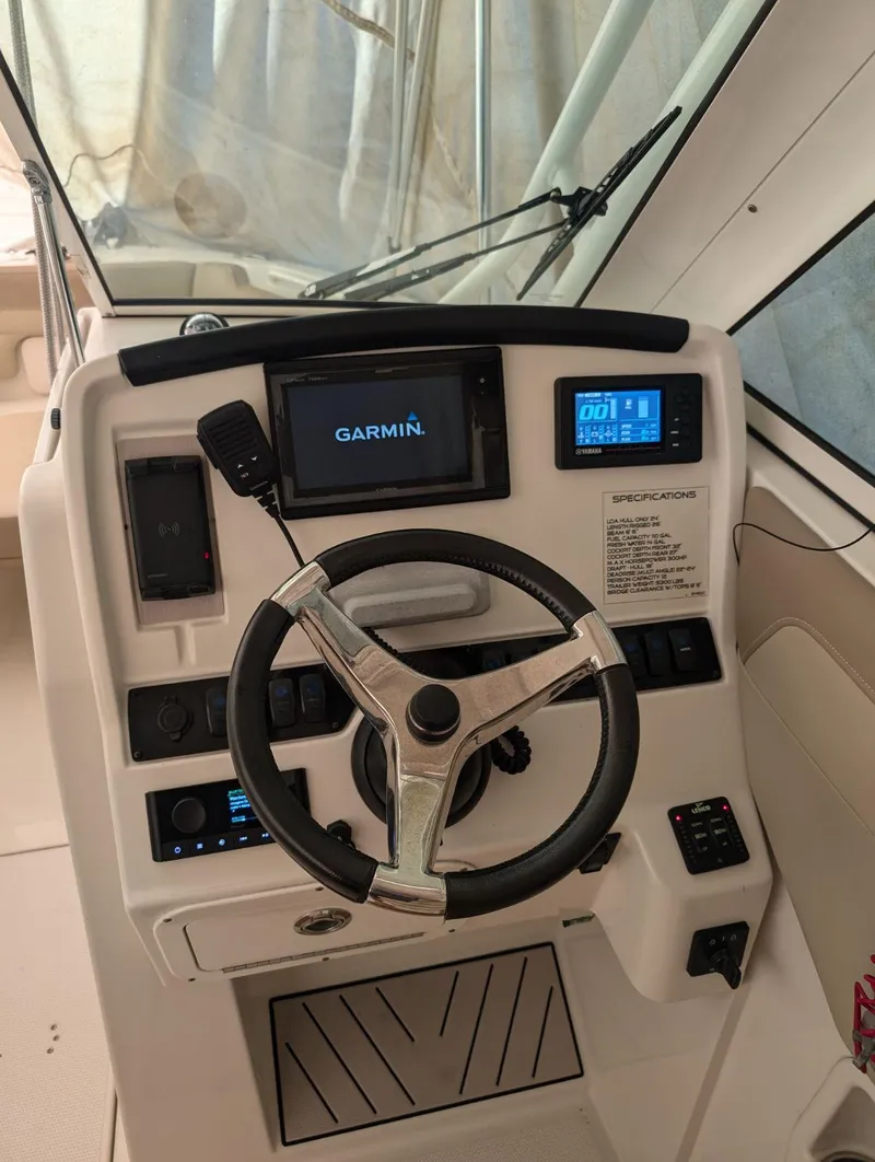Slide: The Image of 2018 Sailfish 245DC boat dashboard with Garmin navigation system and steering wheel. - 2
