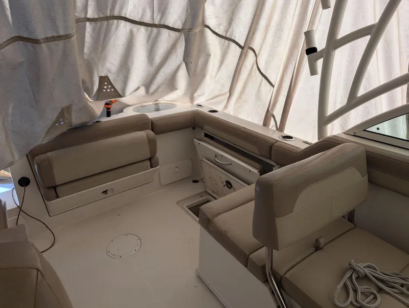 Slide: The Image of 2018 Sailfish 245DC boat interior with beige seating and covered deck. - 3