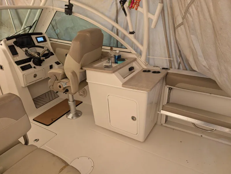 Slide: The Image of Interior of a 2018 Sailfish 245DC boat with helm, seating, and sink area. - 5