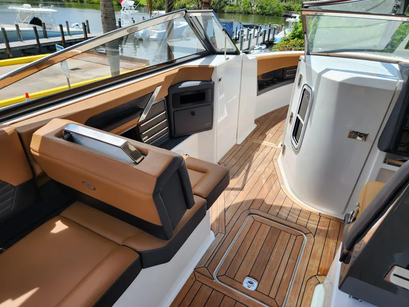 Slide: The Image of 2021 Cobalt A29 boat interior with tan seating and teak flooring. - 10