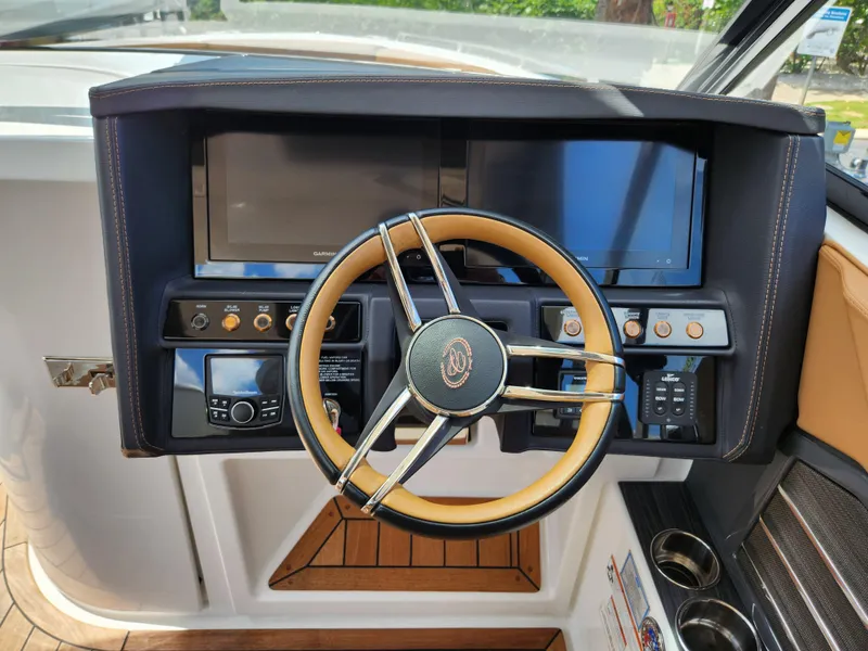 Slide: The Image of Steering wheel and dashboard of a 2021 Cobalt A29 boat, featuring modern controls and displays. - 13