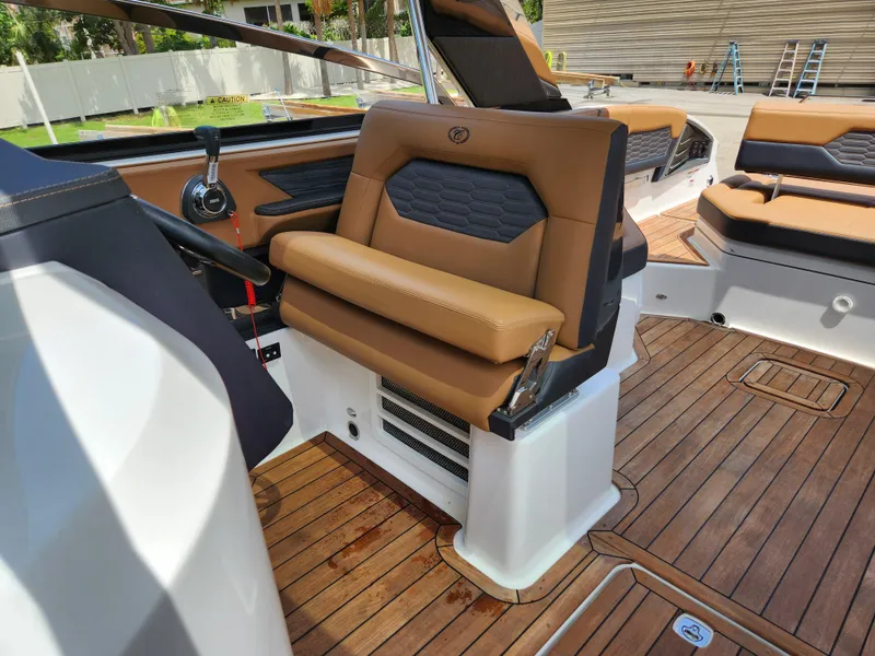 Slide: The Image of 2021 Cobalt A29 boat interior with tan leather seating and wooden flooring. - 20