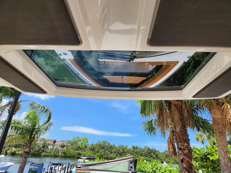Slide: The Image of 2021 Cobalt A29 boat with sunroof, tropical scenery, palm trees, and blue sky. - 29