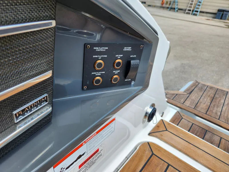 Slide: The Image of Control panel on 2021 Cobalt A29 boat with wood accents and warning label. - 35