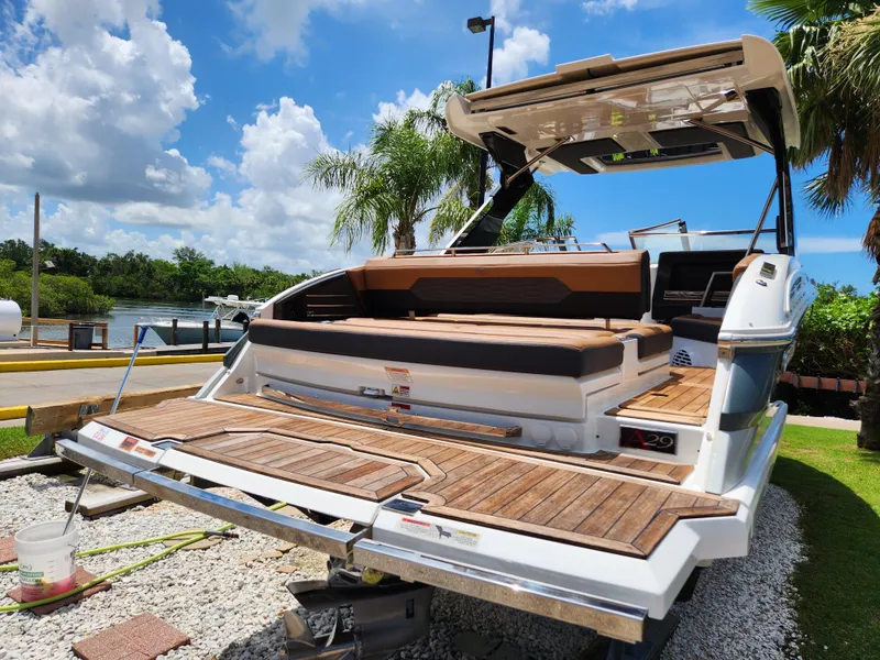Slide: The Image of 2021 Cobalt A29 boat with teak deck, docked under a sunny sky. - 4
