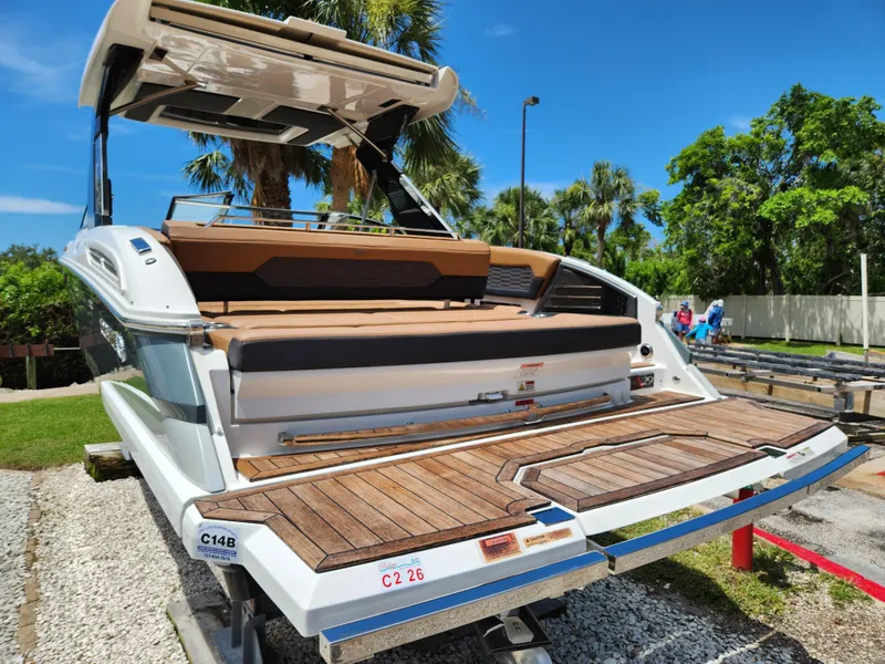 Slide: The Image of 2021 Cobalt A29 boat with teak swim platform, parked outdoors on a sunny day. - 5