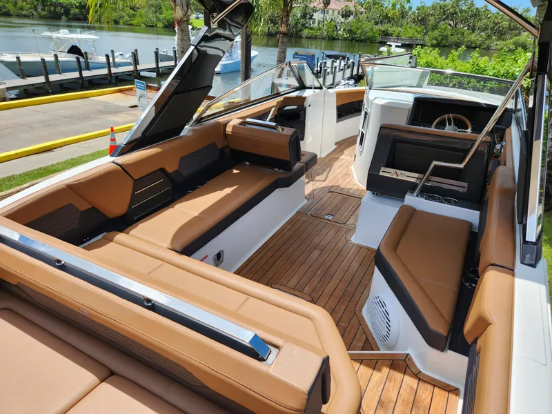 Slide: The Image of 2021 Cobalt A29 boat with luxurious tan seating and sleek design, docked by a scenic river. - 8