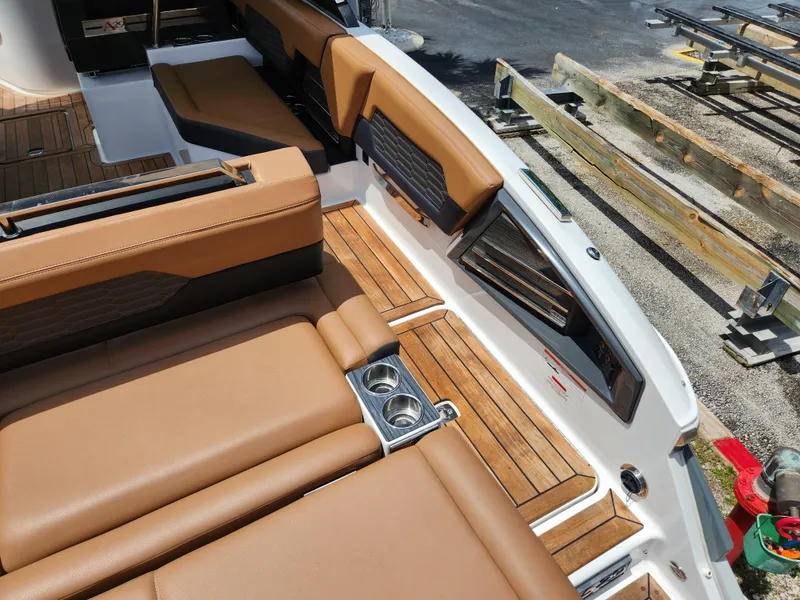 Slide: The Image of 2021 Cobalt A29 boat interior with tan leather seating and wood accents. - 9