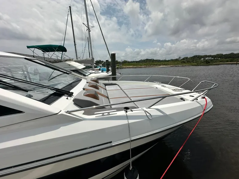 Slide: The Image of 2021 Beneteau GT 32 yacht docked on a calm river under cloudy skies. - 11