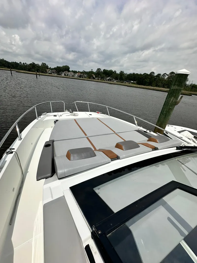Slide: The Image of 2021 Beneteau GT 32 boat with sleek deck design on a calm river. - 16
