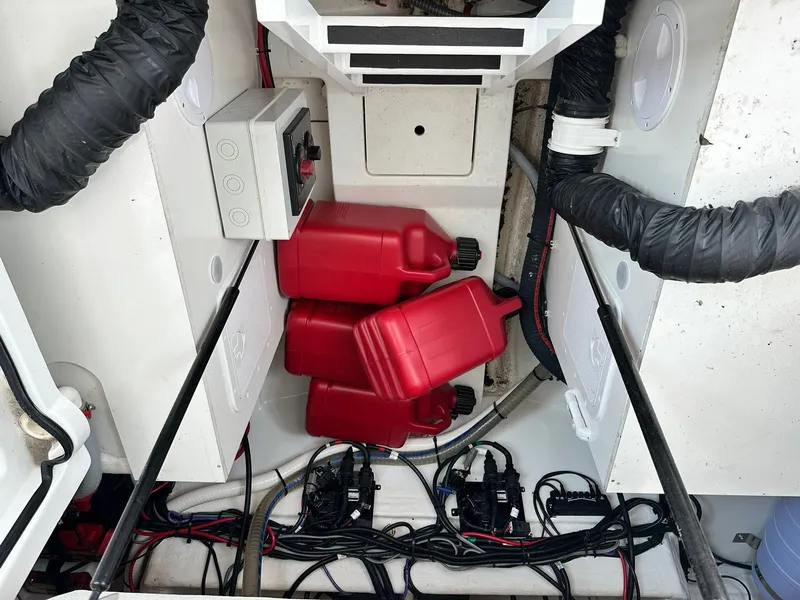 Slide: The Image of Engine compartment of 2021 Beneteau GT 32 with red fuel containers and wiring. - 25