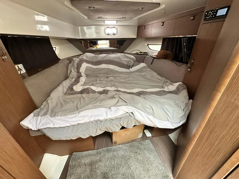 Slide: The Image of Cozy cabin interior of 2021 Beneteau GT 32 with unmade bed and wooden finishes. - 46