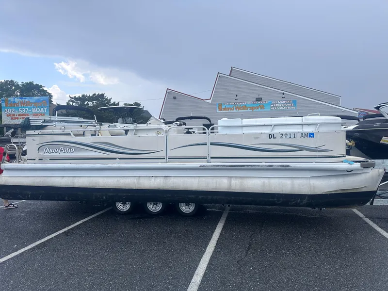 The Image of 2003 AquaPatio 240 RE pontoon boat parked in a lot under cloudy skies. - 1