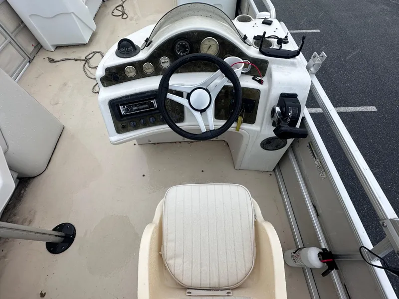 Slide: The Image of 2003 AquaPatio 240 RE boat dashboard with steering wheel and control panel. - 12