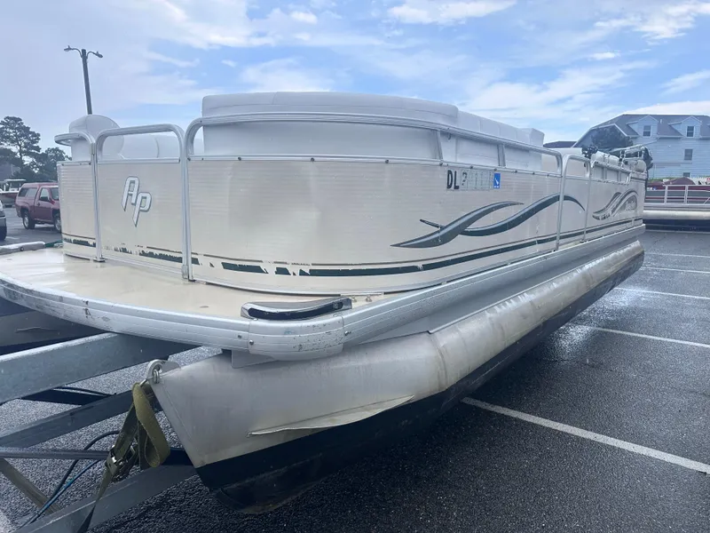 Slide: The Image of 2003 AquaPatio 240 RE pontoon boat parked on a trailer in a lot. - 4