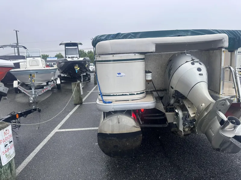 Slide: The Image of 2003 AquaPatio 240 RE pontoon boat parked in a marina lot on a rainy day. - 7
