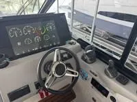 Slide: The Image of 2023 Regal 36 Grande Coupe helm with modern controls and navigation display. - 19