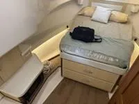 Slide: The Image of 2023 Regal 36 Grande Coupe cabin interior with bed and storage. - 32