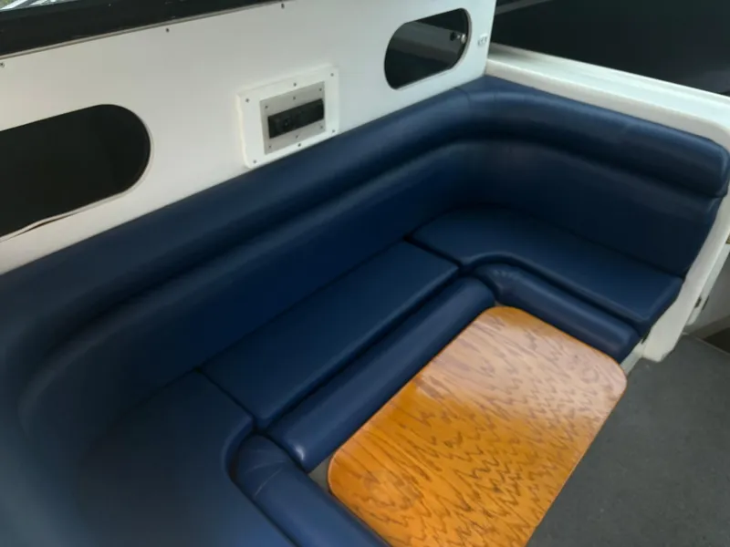 Slide: The Image of 1998 Penn Yan 269 Legend boat interior with blue seating and wooden table. - 11