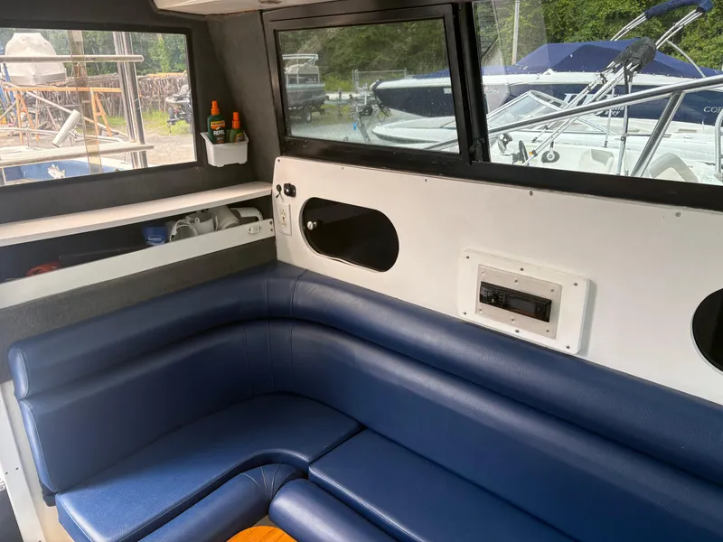 Slide: The Image of Interior of 1998 Penn Yan 269 Legend boat with blue seating and window view. - 12